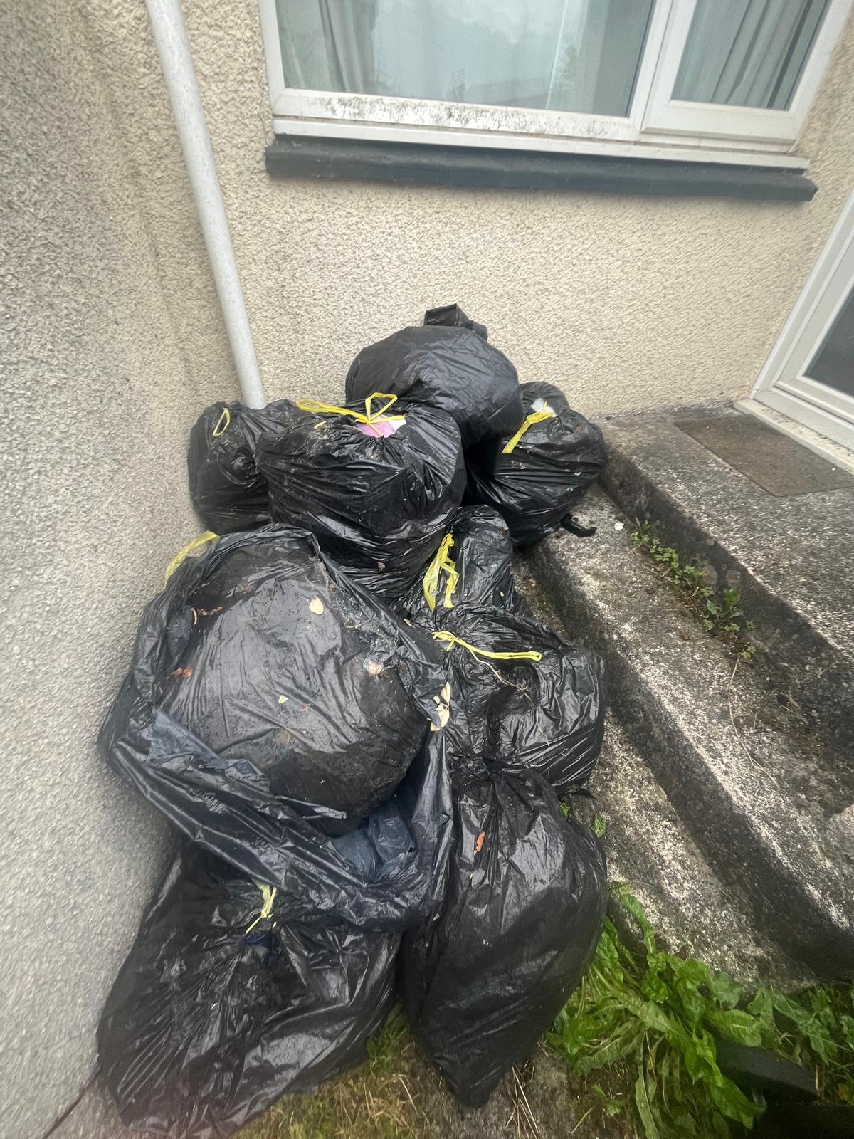 Black bin bags stacked outside a house in Cornwall waiting for Lanora House collection